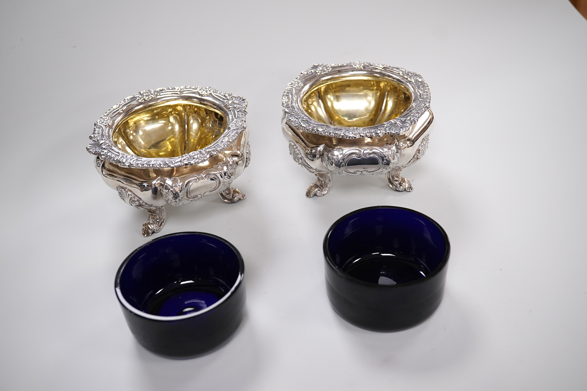 A pair of early Victorian silver cauldron salts, by John Tapley, London, 1838, with later blue glass liners, diameter 94mm, together with a pair of George IV silver Old English pattern condiment spoons, London, 1828.